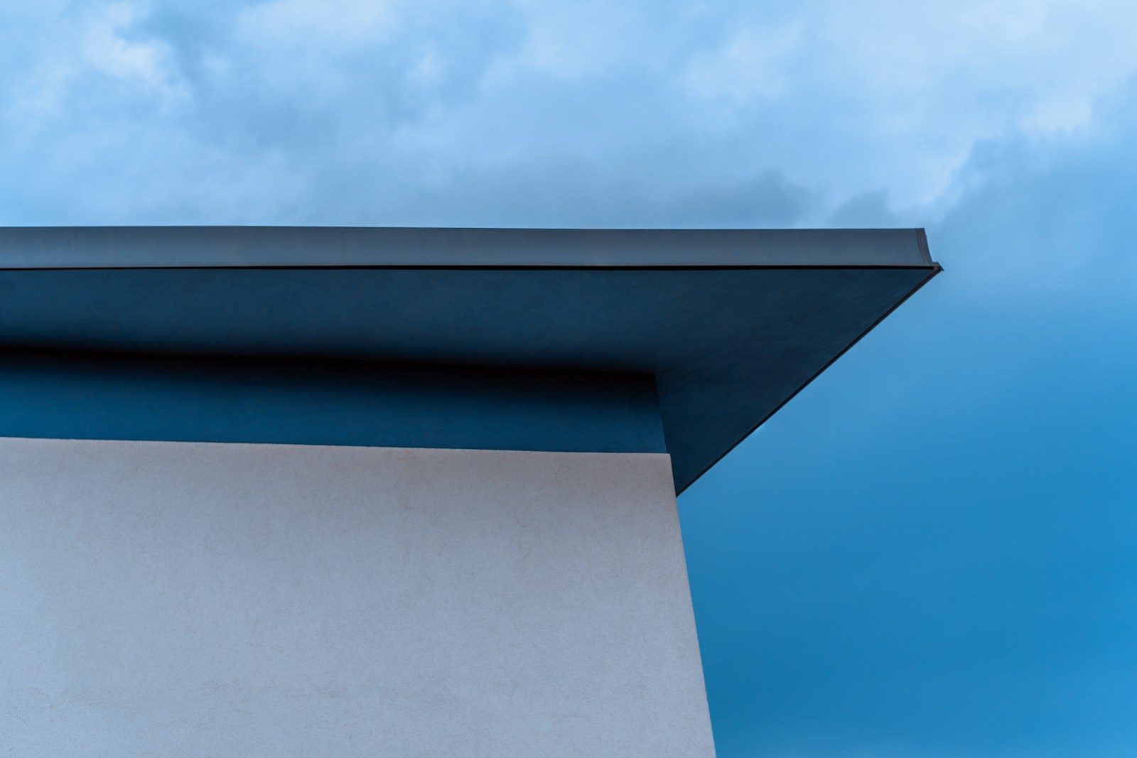Strakke rand van een plat dak tegen een blauwe lucht